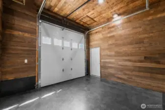 Clean and spacious garage with concrete floors and wood-finished walls.