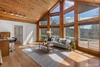 Main living room with soaring windows, T&G ceilings.