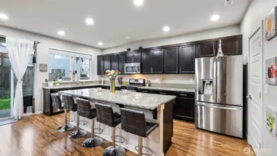 Just off the kitchen, sliding doors lead to a covered patio overlooking a fully fenced backyard—perfect for al fresco dining, summer barbecues, or relaxing under the stars.