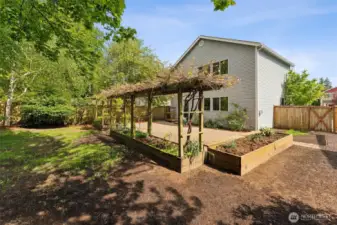 Grass area plus garden beds. Space for additional storage sheds.