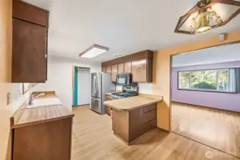 Kitchen includes a convenient eating bar for two — perfect for casual meals or morning coffee. A great blend of function and potential in the heart of the home.