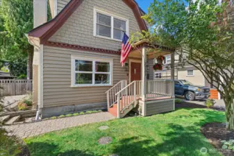 Mature landscaping and stone pavers welcome you to the covered front porch
