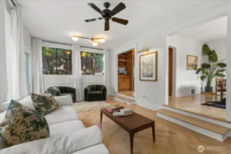Second living area adjacent to the kitchen and dining, with stylish herringbone flooring that adds character and warmth.