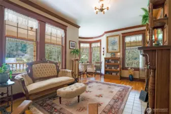 An elegant parlor with wood-burning fireplace and hardwood flooring is a treat as you step inside to this period appropriate space.