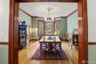 A formal dining room with vintage lighting and stained glass window accents is the perfect place to celebrate holidays and enjoy guests. Beautiful hardwood flooring too.