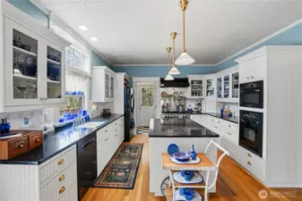 Authentic tin celiing decorates this amazing kitchen, with its gorgeous corian counters, Blue Star 6-burner gas cooktop (brand new door), additional wall oven, and custom white cabinetry.  Notice the beautiful leaded glass window above the no-edge sink.