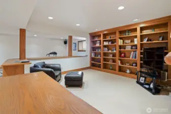 Custom shelving accents the media room, and can lighting keeps this space light and bright.