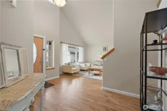Step into a light-filled living space, where a welcoming foyer and soaring vaulted ceilings create an open, airy first impression.