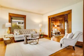 The front parlor offers light and elegance with windows facing south and east. Look out across the wraparound porch to the neighborhood trees and activity of people going to and from nearby schools.