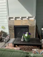 Outdoor fireplace under covered patio.