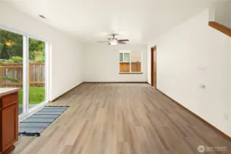 Great room off kitchen with a ceiling fan and light - powder room on the right.