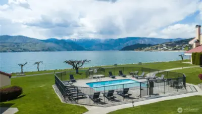 The community boasts 900 ft of waterfront with sandy beach and on-site security. Amenities include dock, boat launch, 5 pools, hot tub, 6 tennis courts, gym, racquetball court, game room, playground, sport court, volleyball court, EV charging, walking path, and private clubhouse for owners.
