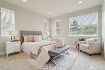Luxurious primary suite features large windows and ensuite bath