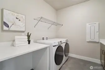 Second floor laundry room with built-in cabinetry and extra folding space