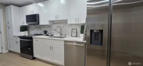 Main Home: Kitchen with Sleek Appliances and an Elegant Full Backsplash