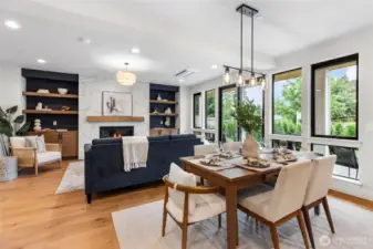 The expansive windows flood the space with natural light, enhancing the airy ambiance and drawing attention to the lush greenery just beyond. Their clean lines and generous scale seamlessly connect the indoors with the outdoors, adding both brightness and tranquility to the room.