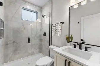 This full bathroom combines clean lines and modern finishes for a polished, spa-like feel. With layered lighting and sleek tilework, it’s both functional and visually refined.