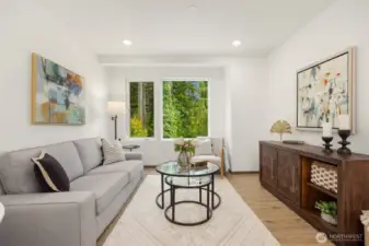 Through the living room’s wide window, lush forest views create a private, tucked-away feel.