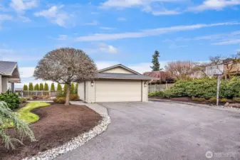 A large driveway with an additional parking space to the east of the garage. Covered storage behind the garage too for lawn and play equipment.