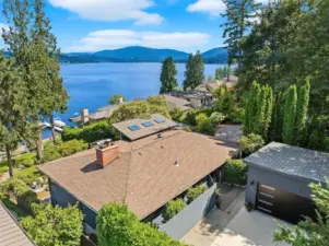 An aerial view of the garage, parking pad, entrance to the home, yard and dreamy views.