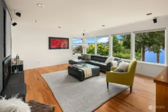 The massive main floor living room features a welcoming fireplace and sports a panorama of windows to bring the outside in.