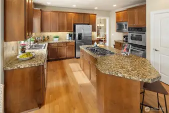 This grand kitchen has  Stainless Steel Appliances. Including dual wall ovens, gas cooktop on the island, microwave oven, dishwasher, and refrigerator.  Nice granite counter tops and tiled backsplash, and under the cabinet lighting too!  A big pantry closet with pull out shelves, and lots of rich cherry wood finished cabinet space.
