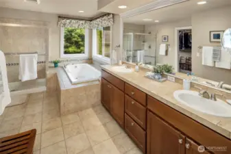 This luxurious Primary Suite Bathroom features dual sinks, nice tile counters and floors, deep soaking tub, a large  separate shower, toilet room, and big walk-in closet with custom shelving & organizers!