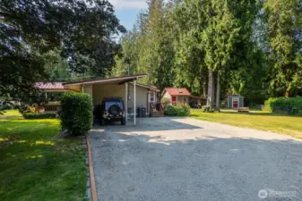 Entry into the property. Covered parking attached to the home and plenty of parking space for guests.