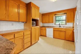 Bay window in kitchen with all appliances included and generous cabinetry for storage.