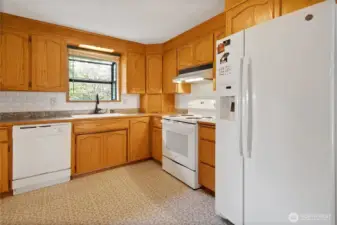 Bay window in kitchen with all appliances included and generous cabinetry for storage.