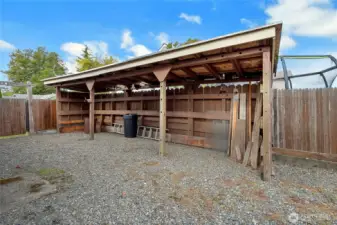 Additional covered storage in gravel off the backyard.