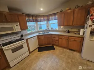 Spacious kitchen with lots counter space and light from three windows.