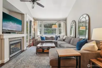 Gas fireplace, ceiling fan and large windows to forest view.