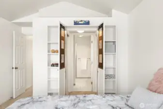 Clever bookshelves hide the opening to the walk-in closet leading to shared bathroom.