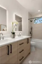 Full bath with dual sinks and a combo shower/tub.