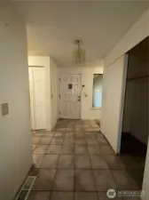 View of the entry way from the living room. Laundry area is to the left.