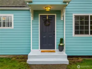 This freshly painted porch and front door invites you in.