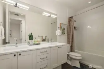 This large full bath offers a double sink vanity full of storge space with a smooth top vanity giving room for everyone. The modern lighting is mounted in the mirror for a flattering look. The tub and shower are finished off with classic subway tile for a timeless look.