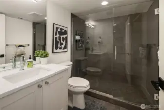 A well-dressed three-quarter bath serves the lower level with an impressive oversized walk-in shower, seamless glass door and handsome custom tile.