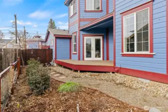 Primary bedroom deck overlooks a carefully landscaped side yard.