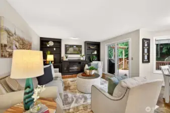 This inviting family room offers a relaxed setting with direct access to the outdoor living spaces through sliding glass doors. Built-ins and the electric fireplace add warmth and everyday practicality.