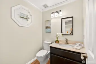 The main floor powder bath is a smart and stylish touch for guests, featuring a vanity with ample counter space. An accent window adds natural light and character to this convenient half bath.