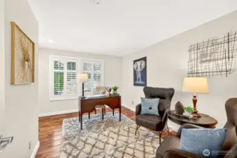 Another bedroom features hardwood floors and crisp, updated finishes for a clean, timeless feel. Plantation shutters add privacy and light control, creating a comfortable space for work, guests, or everyday living.