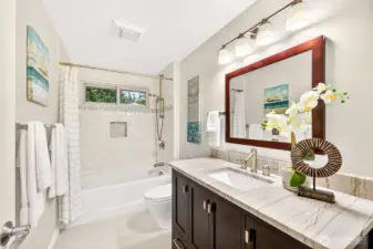 The updated hall bath pairs a refreshed vanity and modern lighting with a bright tub and shower surround. Clean lines and practical storage highlight easy living and maintenance.