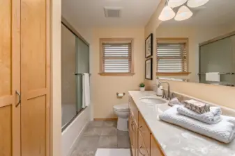 The main bath has been updated with new cabinetry, tile floors and new tub/shower surround.