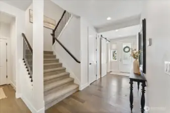 Wide staircase with a stunning wrought iron railing gracefully leads to the upper level, creating a striking architectural statement while enhancing the home's elegant flow.