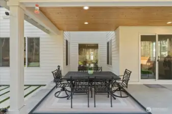 Experience outdoor living at its finest with a covered patio overlooking a meticulously landscaped backyard.
