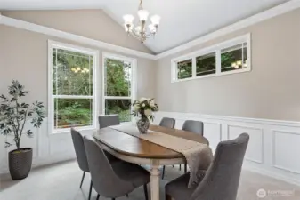 The formal dining room overlooks backyard through large windows and is enhanced by vaulted ceilings, a statement chandelier and refined two-tone detail with chair rail and picture frame molding - classic and sophisticated setting for formal dining.