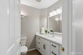 The powder bath has been thoughtfully updated with refinished hardwood floor, new cabinetry, quartz countertops and backsplash, upgraded mirror and new toilet - offering a fresh modern feel.