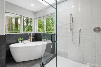 Completing the spa-inspired bath is a freestanding soaking tub set within a tiled surround and framed by windows and skylights creating a light filled retreat. Adjacent is a fully tiled, custom glass-enclosed shower featuring dual faucet valves, shower head and handheld wand for a luxurious experience.